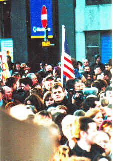 The Betsy Ross Flag - symbol of the America of Jefferson and Washington rather than Wilson and Bush - flies over the faces of the crowd.